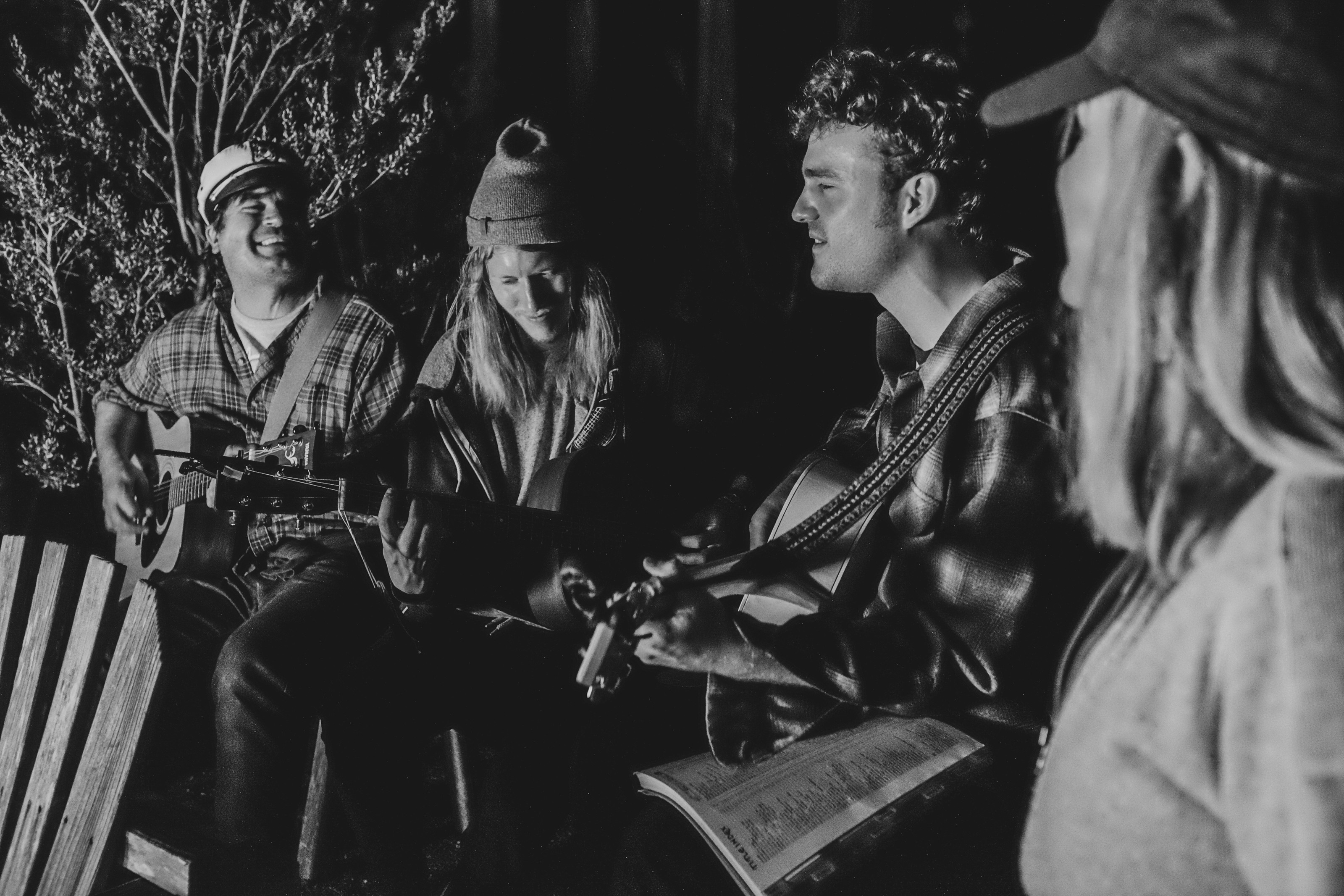 People playing music around a campfire