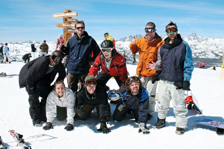 People forming a human pyramid on top of a snowy mountain