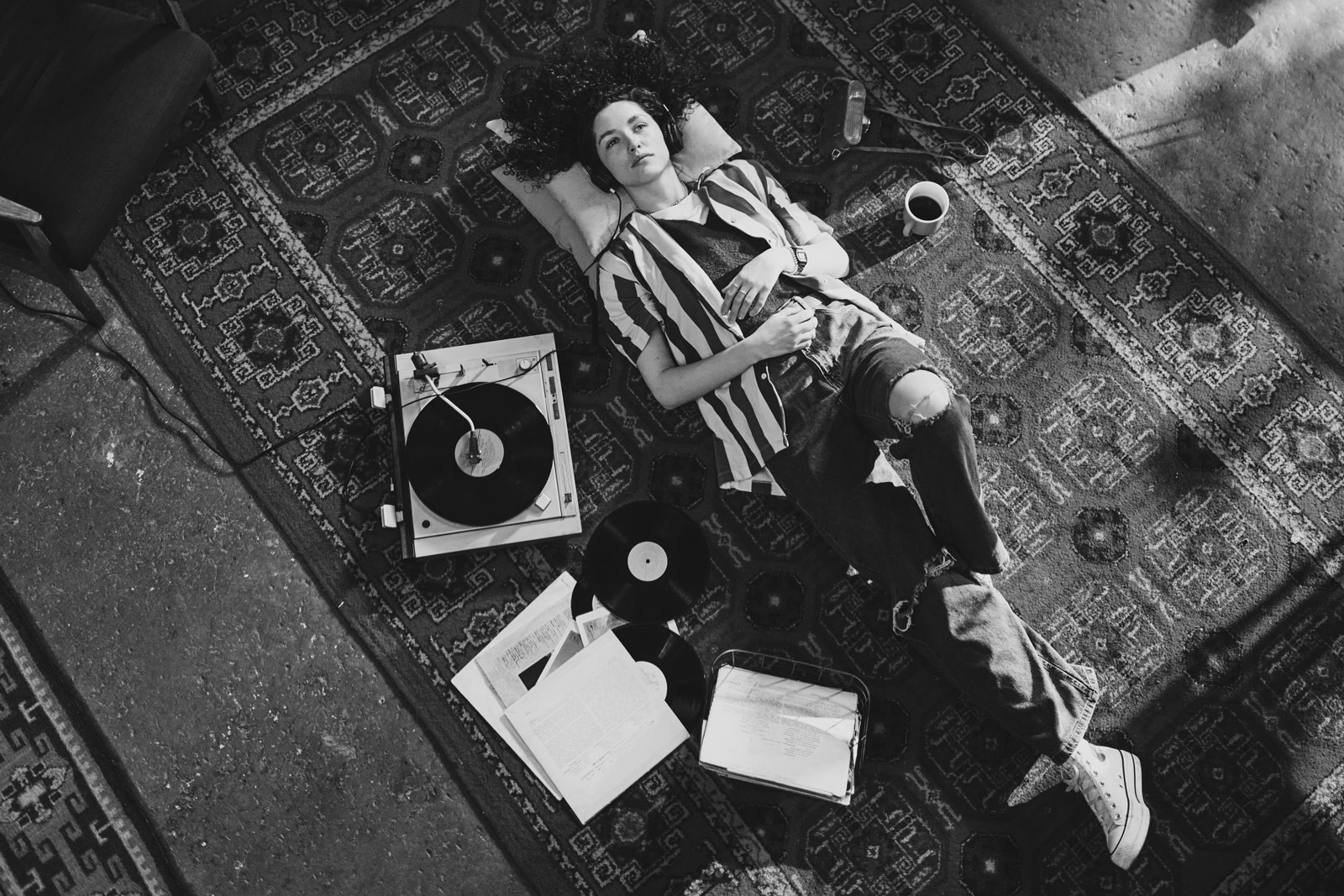 Woman laying on a rug listening to records