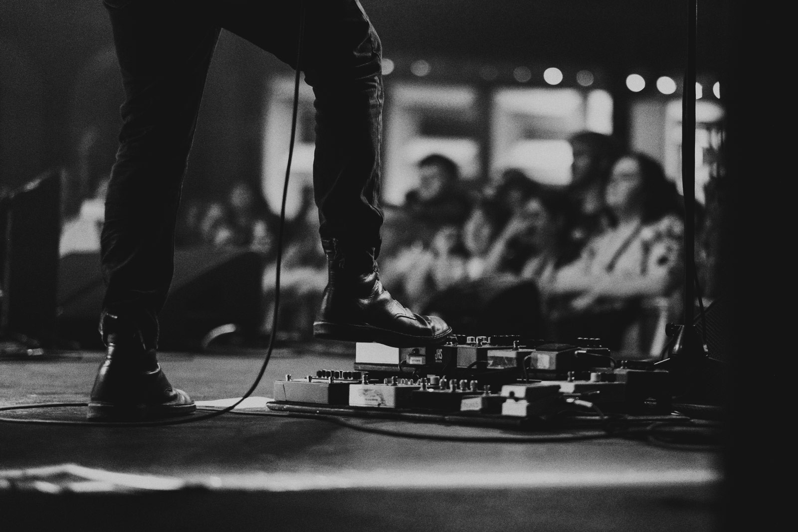 Musician stepping on a guitar pedal board during a live show